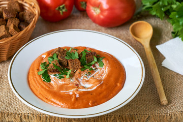 Tomato cream soup with crackers and fresh parsley