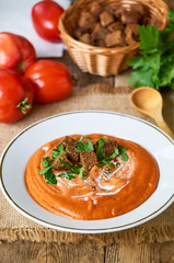 Tomato cream soup with crackers and fresh parsley