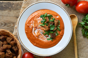 Tomato cream soup with crackers and fresh parsley