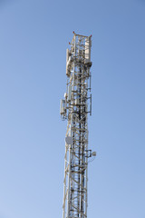 high telecommunication antenna with blue sky background