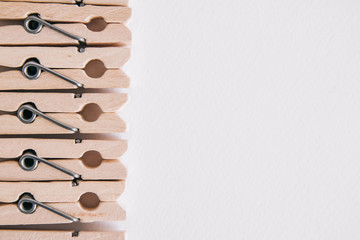 Wooden clothespins on a white background. View from above. Place for text or advertising