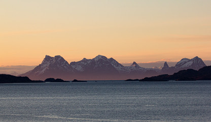 Early morning on a coast of Lofoten, Norway. Pure natural beauty. Soft light and snow covered mountain range.