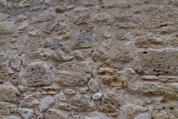 coarse old natural stone wall made of different sized stones