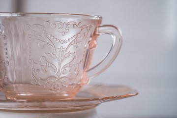 Closeup shot of a decorative glass teacup on a blurred gray background
