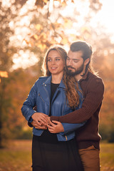 Couple in autumn season colored park enjoying outdoors.