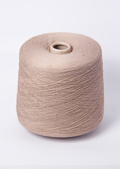 Green bobbin of yarn on a white background.Textile reel on isolated white background.