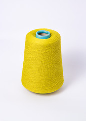 Green bobbin of yarn on a white background.Textile reel on isolated white background.