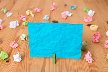 Colored crumpled papers empty reminder wooden floor background clothespin