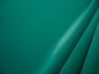 Beautiful smooth elegant wavy emerald green satin silk luxury cloth fabric texture, abstract background design. Card or banner.