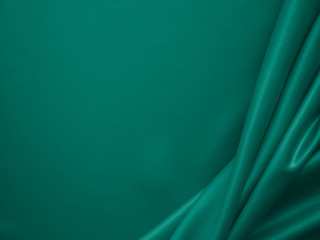 Beautiful smooth elegant wavy emerald green satin silk luxury cloth fabric texture, abstract background design. Card or banner.