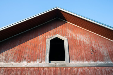 Fototapeta na wymiar open hatch on old red wooden building wall