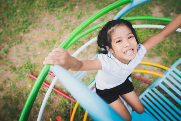 Obraz premium Healthy little kid is playing in the backyard, happy with the swings, rocking horses, slide carriages.