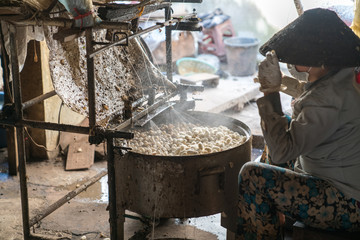 Silkworm cocoon is boilling and unwinding by Vietnamese worman to make silk thread at village in...