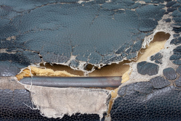 Damaged black leather office chair until seeing the steel frame inside.