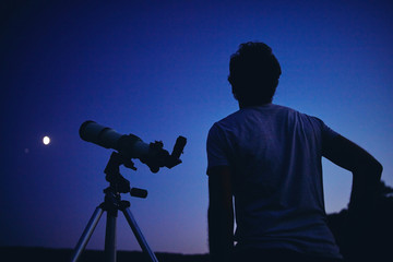 Astronomer with a telescope watching at the stars and Moon. My astronomy work.