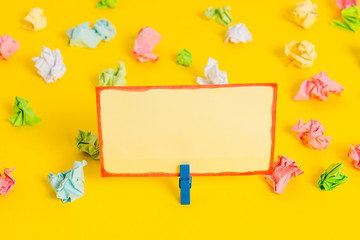 Colored crumpled papers empty reminder white floor background clothespin