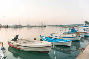 Fototapeta na wymiar Small amateur fishing boats at pier with calm water
