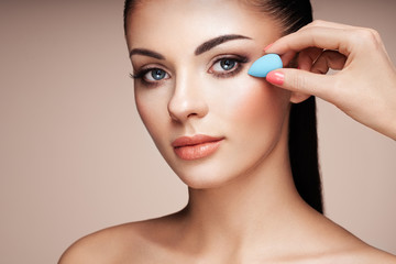 Makeup artist applies skintone. Beautiful woman face. Perfect makeup. Skincare foundation. Sponge...