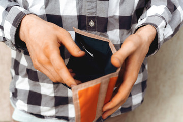 person holding an open wallet, searching for cash money, poor and moneyless concept