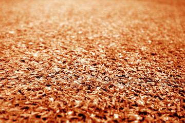 Artificial grass with blur effect in orange tone.