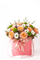 Beautiful bouquet in a red luxury present box with a red bow, isolated on white background