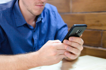 man in blue shirt using mobile phone 