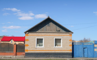 Fototapeta na wymiar Petropavlovsk, Kazakhstan - May 2, 2019: House with a fence against the blue sky, spring landscape.