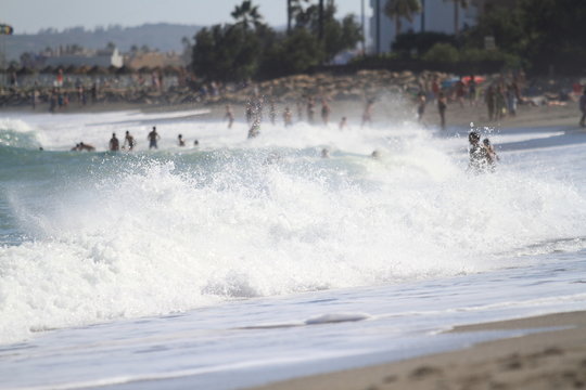 People playing with the big waves on the beach