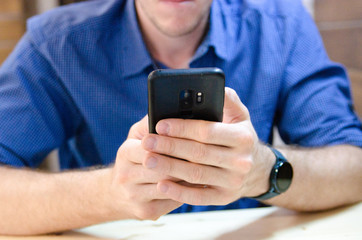 man in blue shirt using mobile phone 