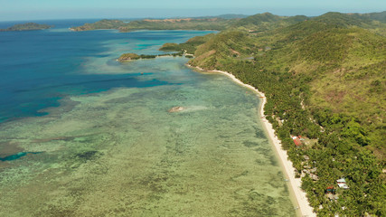 Aerial view tropical island with beach, coral reef and blue lagoon. Busuanga, Palawan, Philippines. Seascape island and clear blue water tropical landscape
