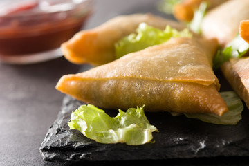 Samsa or samosas with meat and vegetables on black background. Traditional Indian food. Close up