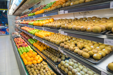 Fresh healthy fruits on shelves in supermarket