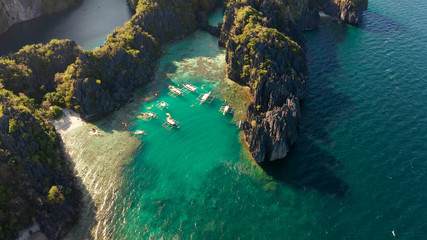 Fototapeta na wymiar Tourist boats over tropical lagoon and coral reef, aerial view. Small lagoon with turquoise water. El nido, Philippines, Palawan. Summer and travel vacation concept.