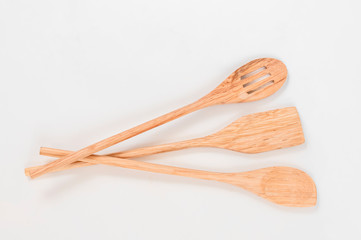 Three beautiful wooden kitchen ladles on a white background.