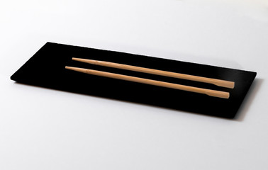Top view of a pair of chopsticks on a black stone table