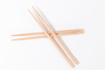 Four chopsticks made of wood insulated on a white background.