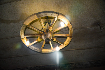 Lamp in the form of a wheel under the ceiling in the wine storage