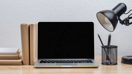 Laptop screen on the desktop with various objects, on a white wall background.Mockup.