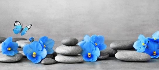 Panele Szklane  Kamienie Zen i fioletowe kwiaty na szarym tle.