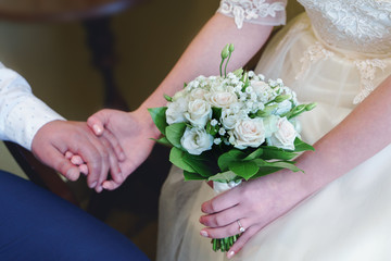Obraz na płótnie Canvas wedding bouquet made from white roses in hands of bride