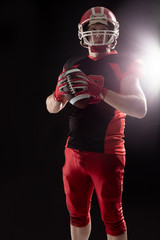 American football player in helmet holding rugby ball