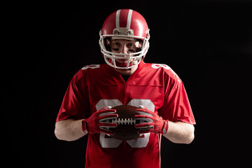 American football player holding rugby ball