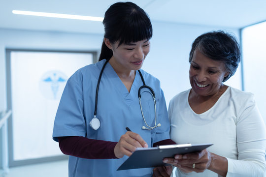 Female Doctor Interacting With Female Patient In The Corridor