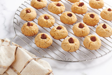 Fresh baked almond cookies on stainless steel grille