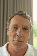 Active senior man looking at camera in a comfortable home
