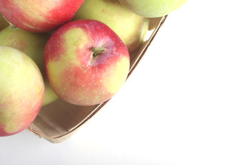 view over pile of apples in a basket on white background