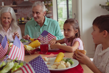 Multi-generation family having food on dining table at home