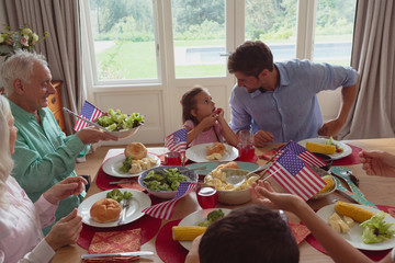 Multi-generation family having food on dining table at home