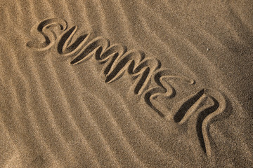 Fototapeta na wymiar summer written on the sand