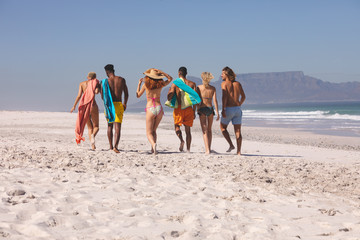 Group of friends walking together on the beach